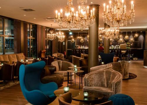 a lobby with chandeliers and a bar at Motel One Berlin-Bellevue in Berlin