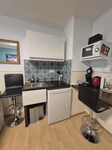 a small kitchen with a sink and a desk at Gästehaus Kampik in Witten