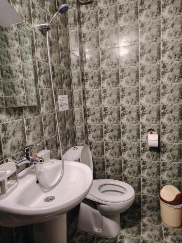 a bathroom with a toilet and a sink at Къща за гости Бащин дом in Apriltsi