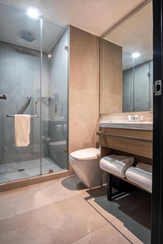 a bathroom with a shower and a toilet and a sink at SJ Grand Hotel Monterrey in Monterrey