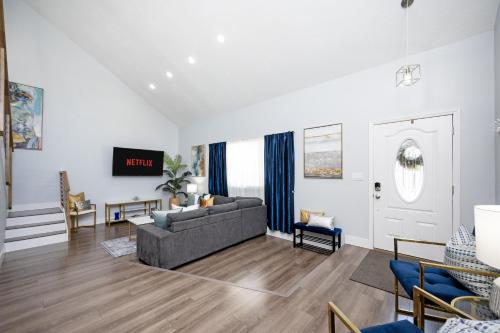 a living room with a couch and a tv at Huge Loft Style 3BR - KING Bed, Pool, WiFi, Washer & Dryer, AC, Free Parking -- IDEAL FOR Medical, Business, Groups, Relocation - near Moffitt Cancer Center and Raymond James Stadium -- Centrally Located in Tampa