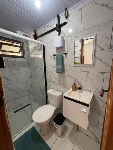 a bathroom with a toilet and a shower and a sink at Vila do Chave Dona Florinda 14 in Itajaí