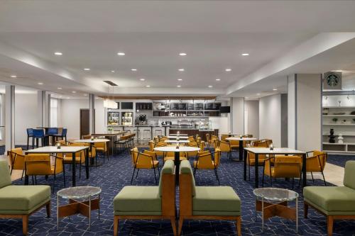 a restaurant with tables and chairs and a kitchen at Courtyard Fargo Moorhead, MN in Moorhead