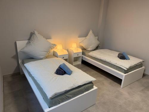 two beds in a room with two lamps on them at WG-Zimmer-Monteurzimmer-Ferienwohnung bis 10 Personen in Aldenhoven