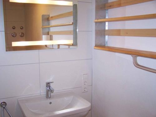 ein weißes Badezimmer mit einem Waschbecken und einem Spiegel in der Unterkunft Ferienwohnung Unterschütz in Ettenheim
