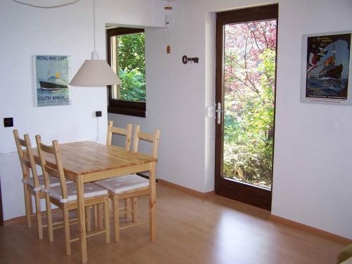 una sala da pranzo con tavolo, sedie e finestra di Ferienwohnung Unterschütz a Ettenheim