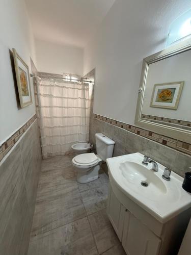 a bathroom with a white toilet and a sink at Elportal in Alta Gracia