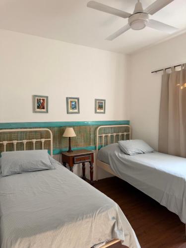 a bedroom with two beds and a ceiling fan at Elportal in Alta Gracia
