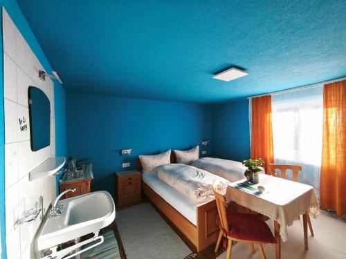 a blue bedroom with a bed and a sink at sonnberg in Ischgl