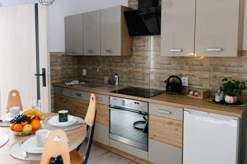 a kitchen with white cabinets and a table with a plate of food at Apartamenty W Zaciszu in Kamienica Królewska