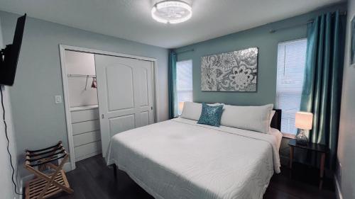 a bedroom with a white bed and blue walls at Huge Loft Style 3BR - KING Bed, Pool, WiFi, Washer & Dryer, AC, Free Parking -- IDEAL FOR Medical, Business, Groups, Relocation - near Moffitt Cancer Center and Raymond James Stadium -- Centrally Located in Tampa