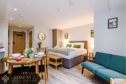 a bedroom with a bed and a table and a couch at Rock Mill - Deluxe Studio Apartments in Stony Middleton