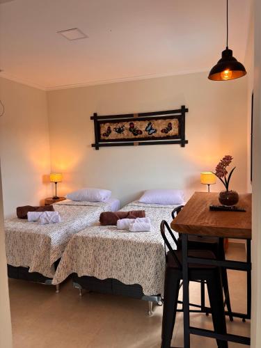 a bedroom with two beds and a table and a tableablish at Departamentos Boutique Misiones in Puerto Iguazú