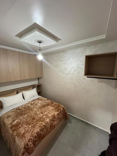 a bedroom with a bed and a tv on the wall at yallah surf house in Taghazout