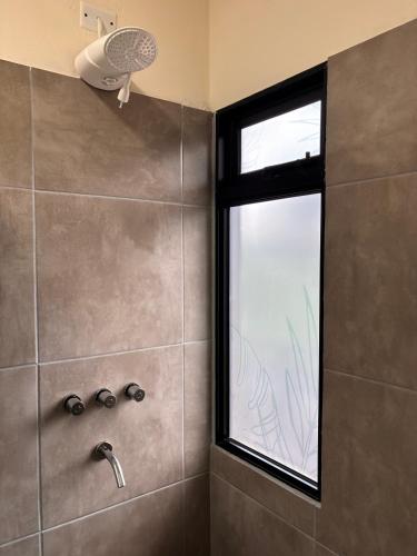 a bathroom with a shower with a window at Departamentos Boutique Misiones in Puerto Iguazú