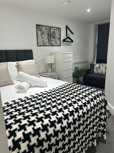 a bedroom with a black and white blanket on a bed at Studio 2 - Eign St Hereford in Hereford
