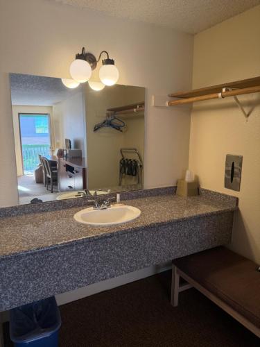a bathroom with a sink and a large mirror at Federal Way Motel in Federal Way