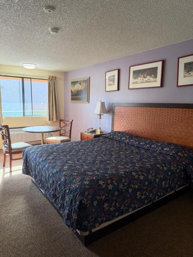 a hotel room with a bed and a table and chairs at Federal Way Motel in Federal Way