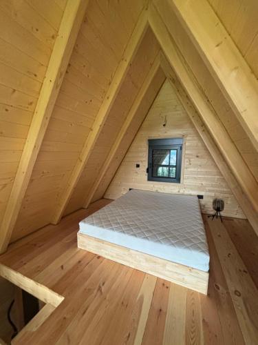 a bed in the attic of a wooden cabin at Vila Mia in Žabljak