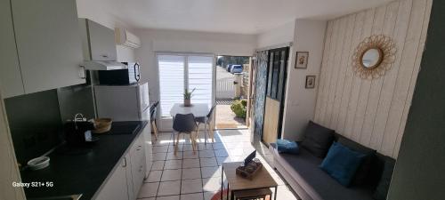 L orangerie في Cannes-Écluse: مطبخ به ثلاجة وطاولة مع كرسي