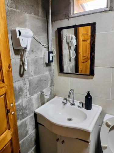 a bathroom with a sink and a mirror and a toilet at Quincho Cabaña Las Marias in Ciudad Lujan de Cuyo