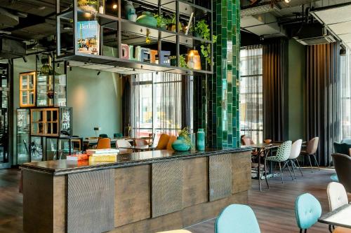a bar in a room with chairs and tables at Motel One Berlin-Hackescher Markt in Berlin