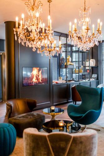 a living room with a chandelier and a fireplace at Motel One Berlin-Bellevue in Berlin