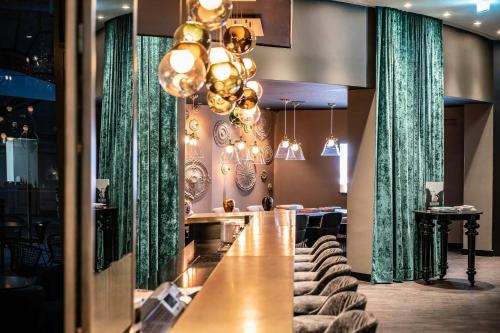 a long table in a restaurant with green curtains at Motel One Berlin-Ku'Damm in Berlin