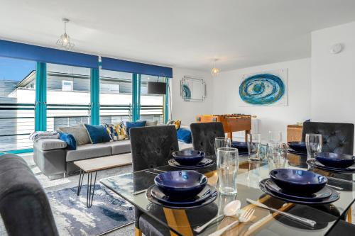 a living room with a table and a couch at PENTHOUSE - Spacious, Stunning River Views, Foosball Table, Central, River Front, V&A, Train Station, City Centre, Lift Access, Free Parking & Fully Equipped by SUNRISE LONG LETS and SERVICED ACCOMMODATION DUNDEE - Reduced Mobile App Price in Dundee