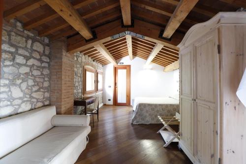 a living room with a couch and a stone wall at Tenuta Maraveja 1462 in Brendola