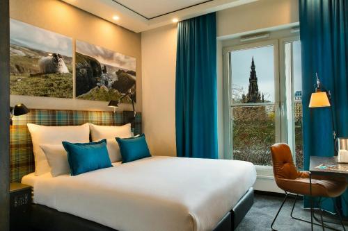a bedroom with a large bed and a window at Motel One Edinburgh-Royal in Edinburgh