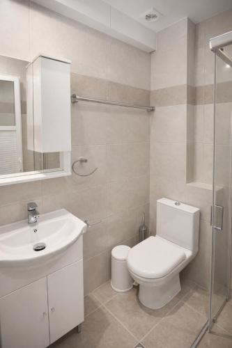 a white bathroom with a toilet and a sink at Casa al' Tati Apartments in Ialysos