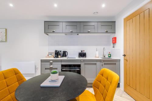a kitchen with a table and two yellow chairs at Rock Mill - Stunning Studio Apartment in Stony Middleton