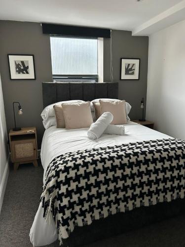 a bedroom with a large bed with a black and white blanket at Studio 5 - Eign St Hereford in Hereford