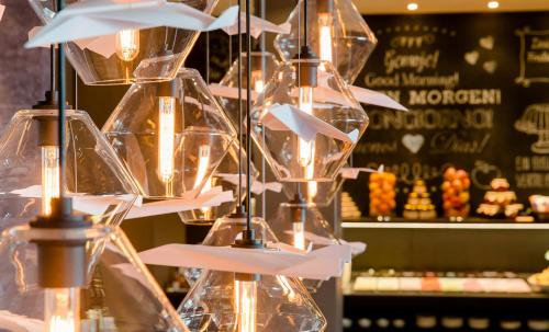 a display in a pastry shop with clear glasses at Motel One Frankfurt-Airport in Frankfurt