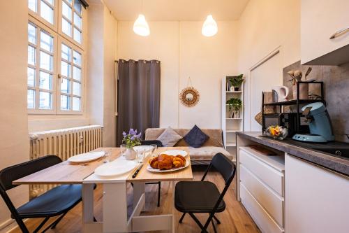 a kitchen and living room with a table and chairs at L'Echo de Saint-Michel - Parking Privé - StyleCosy in Dijon