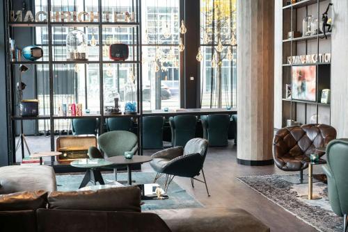 a living room with a couch and chairs and tables at Motel One Berlin-Spittelmarkt in Berlin