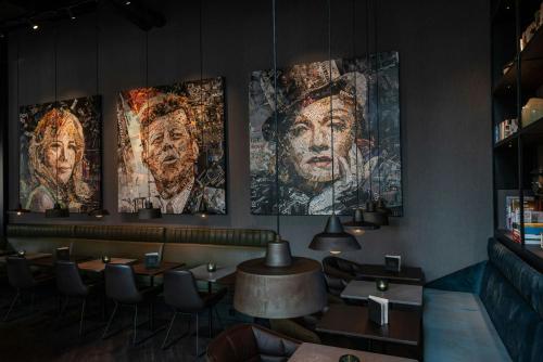 a restaurant with four posters on the wall at Motel One Berlin-Spittelmarkt in Berlin