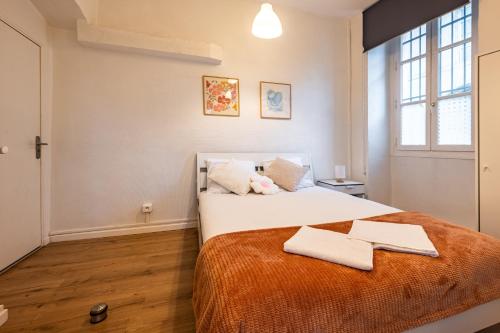 a bedroom with a bed with two towels on it at L'Echo de Saint-Michel - Parking Privé - StyleCosy in Dijon