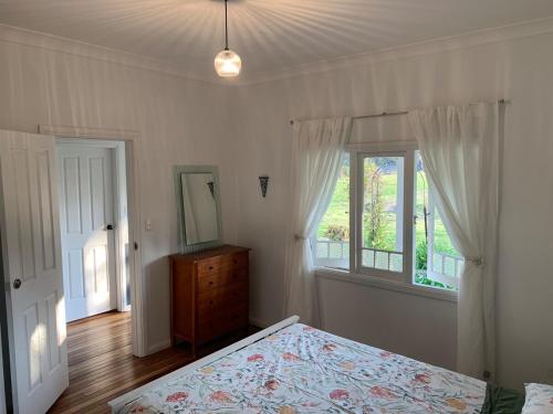 a bedroom with a bed and a dresser and a window at Cobargo ButterHaus in Cobargo