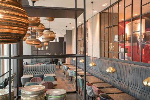 a restaurant with a row of chairs and lights at Motel One Berlin-Upper West in Berlin