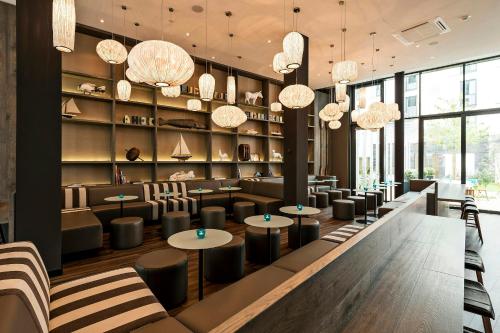 a restaurant with tables and chairs and chandeliers at Motel One Bremen-Altstadt in Bremen
