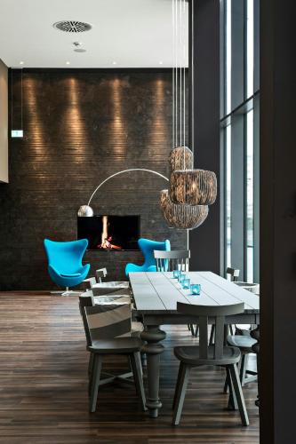 a dining room with a table and chairs and a fireplace at Motel One Bremen-Altstadt in Bremen