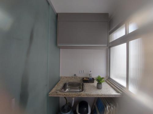 a kitchen counter with a sink and a window at Recanto da Enseada in Guarujá