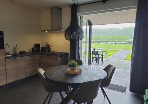 a kitchen and dining room with a table and chairs at Timmershoeve in Vorstenbosch