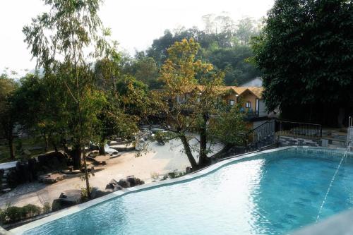 a large swimming pool next to a beach and a house at Lotus Premium Lodge in Ha Giang