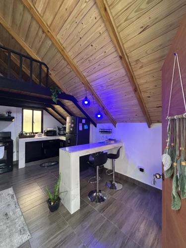 kuchnia z blatem i stołkami w pokoju w obiekcie Lovely tiny studio w mieście Jarabacoa