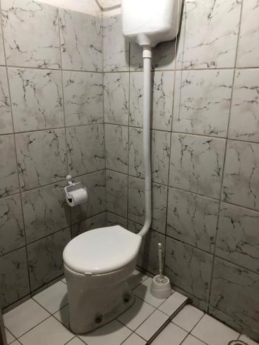 a bathroom with a toilet and a water tank at Casa Estrela do Mar in Conde