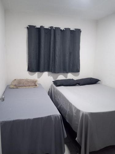 two beds in a room with black curtains at Casa Estrela do Mar in Conde