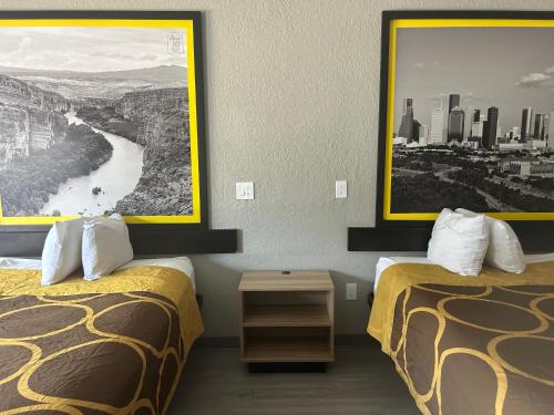 a hotel room with two beds and a picture on the wall at Super 8 by Wyndham Houston/Brookhollow NW in Houston